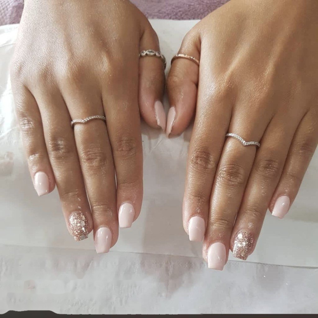 Soft pink acrylic nails with gel overlay and rose-gold glitter accents by Leanne