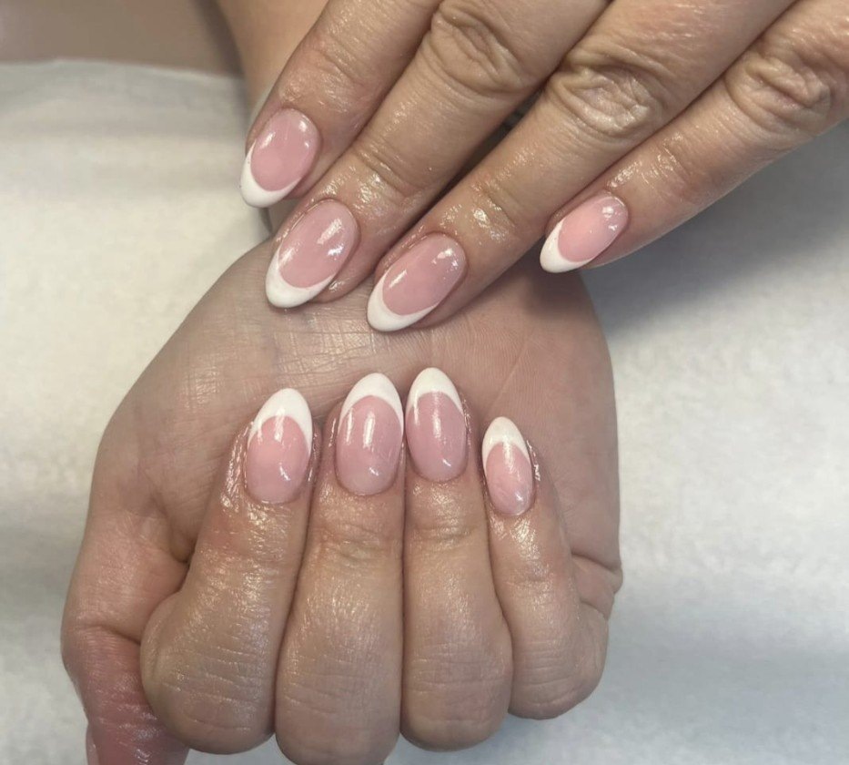 Almond-shaped nude and white BIAB French nails by Leanne