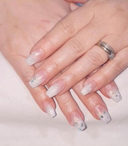 Glitter acrylic nails with delicate blue details by Leanne